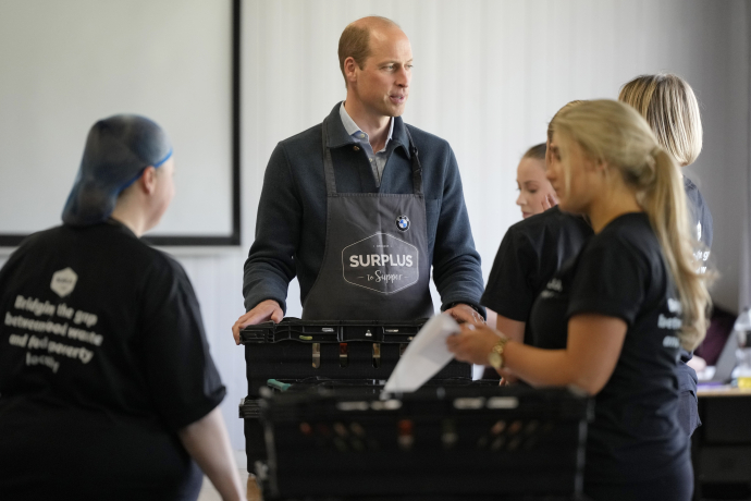 The Prince of Wales helps to pack crates of food at food redistribution charity Surplus to Supper